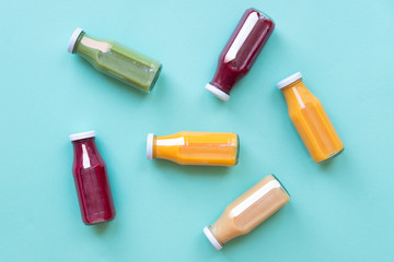 Natural Organic Food Style.Colorful smoothies in bottles isolated on blue background, top view.
