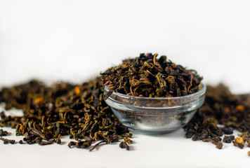 Dry tea leaves. White background. Selective focus.