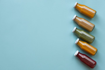 Healthy eating, drinks, diet and detox concept - close up of five bottles with different fruit or vegetable juices for detox plan with copy space