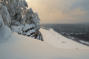 Sunset view from high mountain on frozen river and endless forests