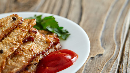 roast meat in a plate on a wooden table. with free text space