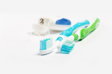Dental floss and toothbrush isolated on a white background.