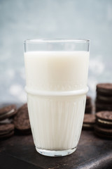 Glass of cold milk and chocolate cookies on the rustic background. Selective focus. Shallow depth of field. 