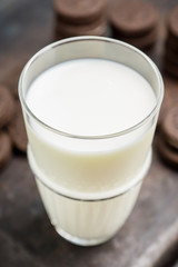 Glass of cold milk and chocolate cookies on the rustic background. Selective focus. Shallow depth of field. 