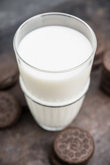 Glass of cold milk and chocolate cookies on the rustic background. Selective focus. Shallow depth of field. 