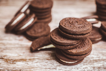 Stack of chocolate sandwich cookies on the rustic wooden background. Selective focus. Shallow depth of field.