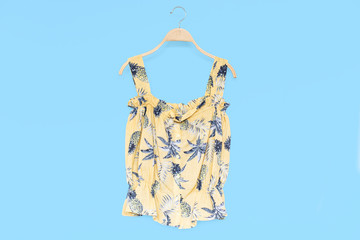 Woman summer blouse with yellow blouse cotton on blue background.