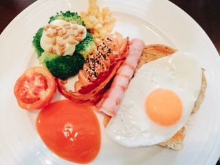 Fried egg, ham, toast, breakfast set, placed on a plate and served