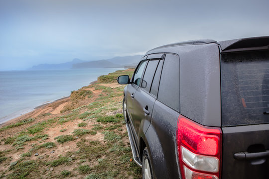 SUV on a high sea shore against the sky.
