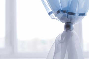 blue curtains are decorated with a decorative ring. comfort in the room.