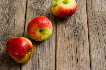 three apples on old wooden background
