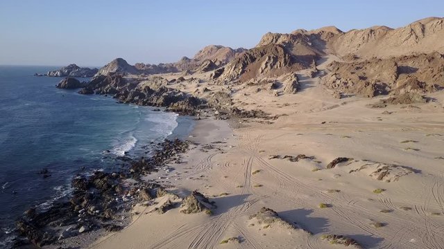 Las Tortolas beach aerial footage at Atacama Desert the sunset ray lights illuminate this amazing and idyllic beach in the middle of the desert, an arid awe landscape crashed by Pacific Ocean waters
