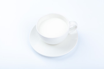 A glass of white milk on a white background
