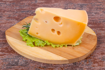 Maasdam cheese  in the board served salad leaves