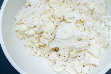Mixing in a bowl of ingredients butter, cottage cheese and flour for the preparation of cookies