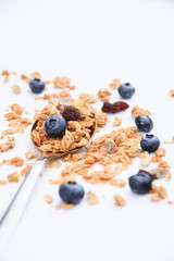 Crispy muesli and blueberry on a spoon Breakfast cereal isolated on white background, selective focus, top view