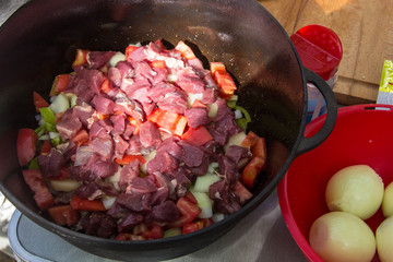 Metal stock pot with soup ingredients vegetables and meat