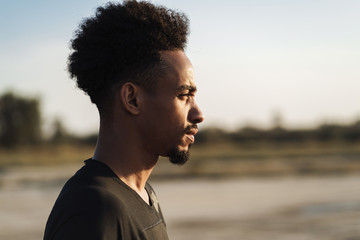 Side view image of a handsome young african strong sports man posing