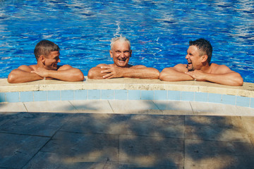 a group of men swimming in the pool