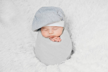 newborn baby lies in a beautiful hat