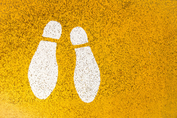 Footprints signs on yellow asphalt road colour.