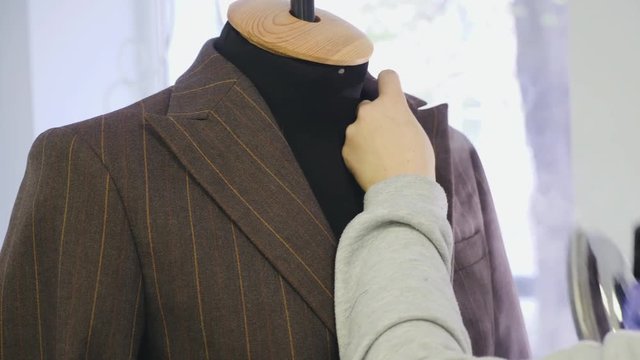 Process of ironing male jacket on the mannequin