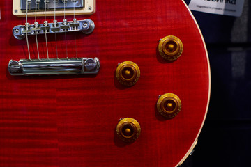 Details close-up of an electric guitar in red. Music concept