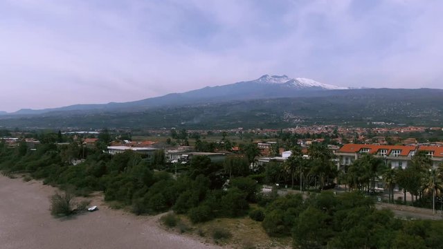 Aerial dolly view of mount Etn from a beach in the East coast of Sicily