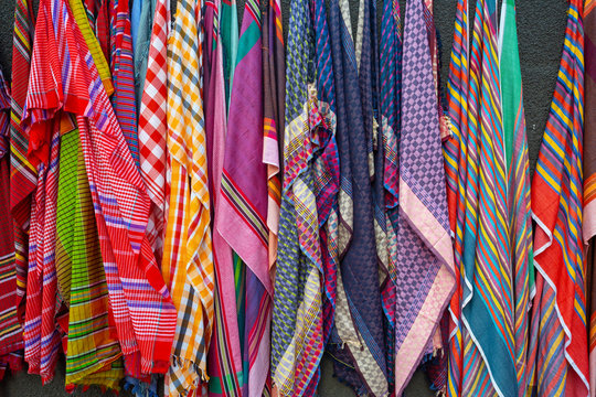 A Bangladeshi vendor sits under his display of traditional towels or gamcha as he waits for customers on a street of Dhaka.