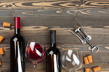 Bottle of wine and cork and corkscrew on wooden table
