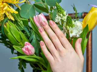 stylish colorless female manicure on pink background