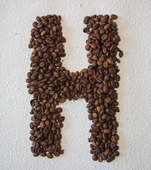 Image of roasted coffee beans shaped alphabet on a white background