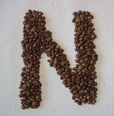 Image of roasted coffee beans shaped alphabet on a white background