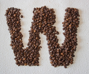 Image of roasted coffee beans shaped alphabet on a white background