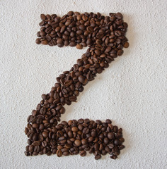 Image of roasted coffee beans shaped alphabet on a white background