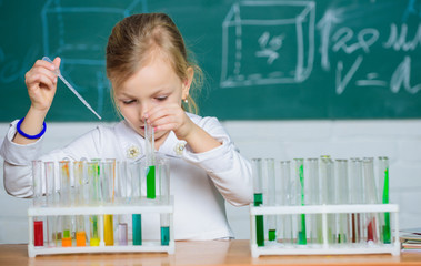 Interesting approach to learn. Future scientist. Explore and investigate. School lesson. Girl cute school pupil play with test tubes and colorful liquids. School chemical experiment. School education