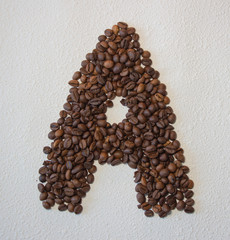 Image of roasted coffee beans shaped alphabet on a white background