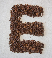 Image of roasted coffee beans shaped alphabet on a white background