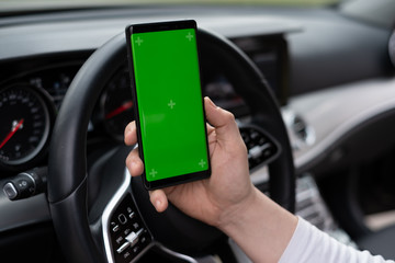Man hold smartphone in car on dashboard background