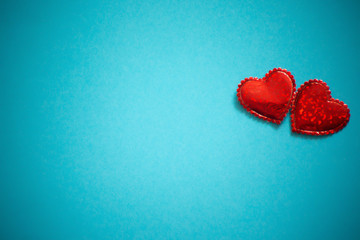 Two sparkling hearts together on blue background