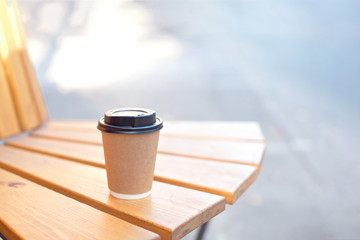 Paper cup of coffee or tea on wooden table on street food festival