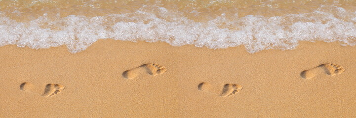 Fototapeta Texture background Footprints of human feet on the sand near the water on the beach obraz