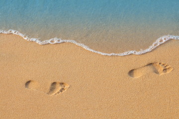 Texture background Footprints of human feet on the sand near the water on the beach © Kozlik_mozlik