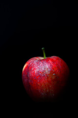 One red apple on black background