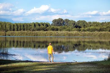 man standing on the edge of the lake, tranquility mood in the nature