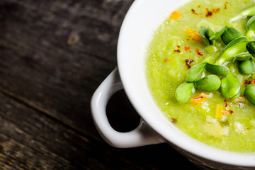 Hot green peas soup on the rustic background. Selective focus. Shallow depth of field.