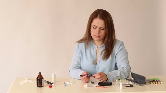 Close-up girl diabetic changes the Lancet on the handle of the glucometer. Handle scarifier for a modern glucometer. Measurement of blood glucose levels at home using a glucometer.