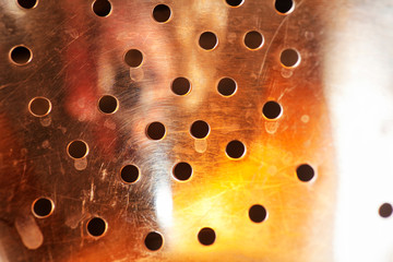 Perforated steel surface with colorful reflection