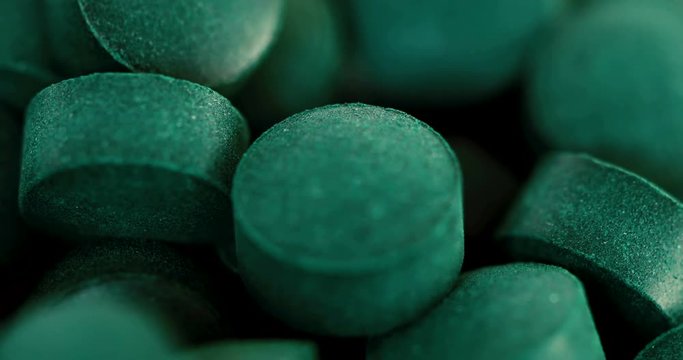 Close up chlorophyll spirulina tablet rotation , healthy detox suplement , 4k dci resolution