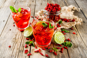 Homemade goji lemonade with lime and mint, rustic wooden background copy space